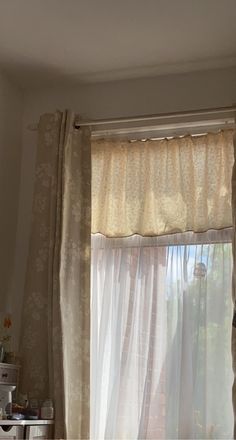 the curtains are pulled back in front of the window with sheer drapes on them