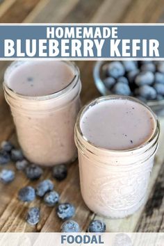 two jars filled with blueberry kefir sitting on top of a wooden table