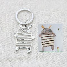 an animal keychain is shown next to a card with the image of a sheep on it