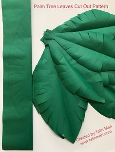 a book with green paper leaves cut out to make a palm tree ornament