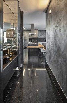 a kitchen with black marble floors and stainless steel appliances on the wall next to it