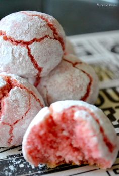 three powdered sugar cookies sitting on top of a newspaper next to a cup of coffee