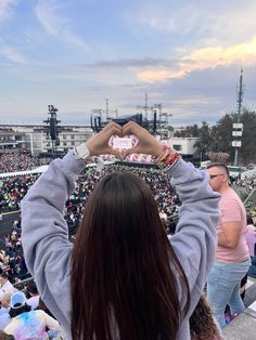 a woman holding up a heart shaped object in front of a crowd