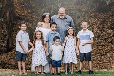 a family posing for a photo in front of some trees