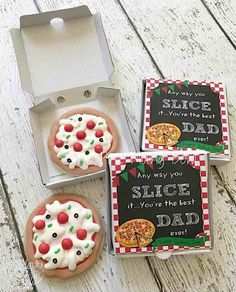 three decorated cookies are in a box on the table next to a card that says slice your dad