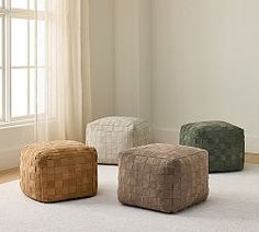 three different colored stools sitting on top of a white rug in front of a window