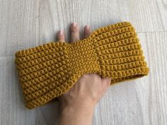 a hand is holding up a crochet headband