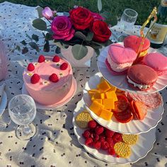 a table topped with cakes and desserts covered in frosting next to wine glasses