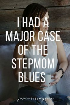 a woman sitting on top of a white couch next to a wooden wall with the words i had a major case of the stepmom blues