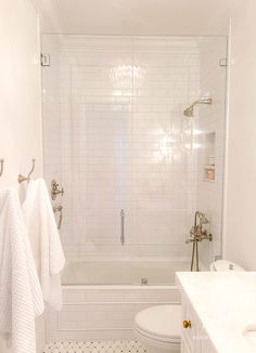 a bathroom with white tile and black and white flooring