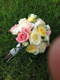 a bridal bouquet laying in the grass with flowers on it's back end