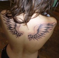 the back of a woman's shoulder with an eagle tattoo on it