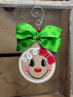 a christmas ornament hanging from a door with a green bow and polka dots