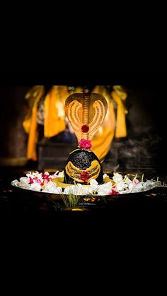 an elaborately decorated vase sitting on top of a table next to flowers and candles