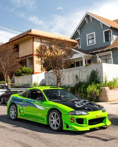 a green sports car parked in front of a house