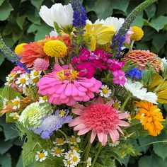 a vase filled with lots of different colored flowers