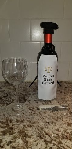 a wine bottle sitting on top of a counter next to a glass and corkscrew