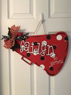 a red door hanger with the word faith on it and polka dot ribbon attached to it