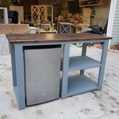 a kitchen island made out of an old refrigerator freezer and shelves in a garage