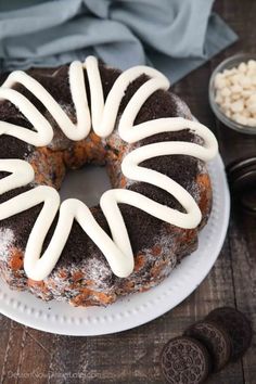 a chocolate bundt cake with white icing on a plate