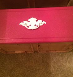 a pink bench sitting on top of a carpeted floor