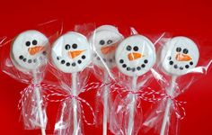 six frosted snowman lollipops wrapped in cellophane on a red background