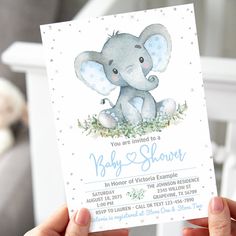 a person holding up a baby shower card with an elephant on it's back