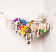 several stuffed animals are in a hammock hanging on the wall