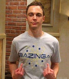 a man standing in front of a brick wall wearing a t - shirt that says bazinga