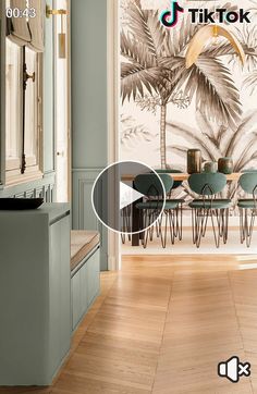 an image of a dining room with palm trees on the wall and wood flooring