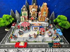 a toy town with cars and people on the street