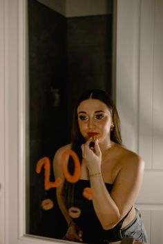 a woman brushing her teeth in front of a mirror with the number 10 on it