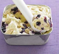 blueberry ice cream in a metal container with a white stick sticking out of it