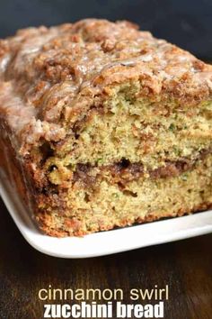 a loaf of cinnamon swirl zucchini bread on a white plate with a bite taken out