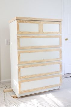 a white dresser sitting on top of a hard wood floor