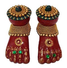 pair of red and gold hand shaped vases with beads on the top one is holding a green ball