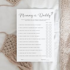 a printable mommy or daddy checklist sitting on top of a bed next to a crocheted blanket