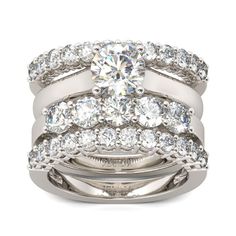 a white gold wedding ring set with two rows of diamonds on each band and a center diamond in the middle