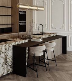 a kitchen with marble counter tops and stools