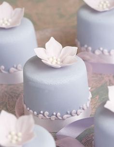 there are many blue cakes with white flowers on them