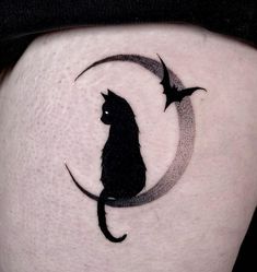 a black cat sitting on top of a crescent moon