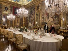 a fancy dining room with chandeliers and tables set up for formal dinner guests