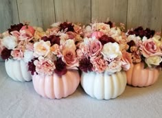 several white pumpkins with flowers in them