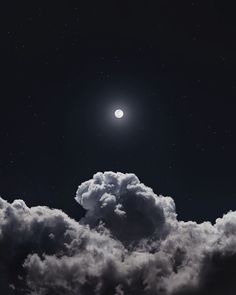 the moon is in the sky above some clouds