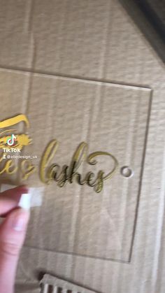 someone is holding up a piece of cardboard with the word cake on it in gold foil