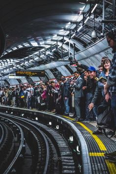 a group of people waiting for the subway to arrive