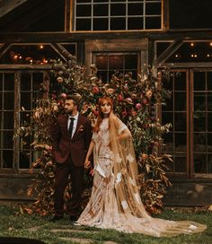 a bride and groom standing in front of a house