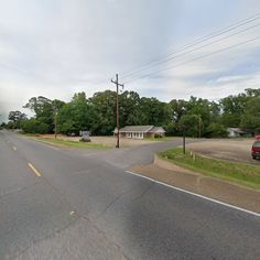 an empty street with houses and trees in the backgroung, as seen from a google street view camera