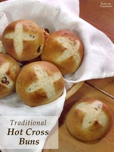 four hot cross buns in a basket on a table