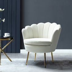 a white chair sitting on top of a floor next to a table